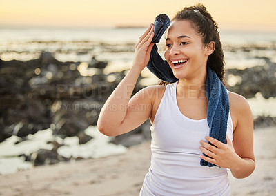Buy stock photo Cropped shot of an attractive young woman wiping herself down after a workout on the beach