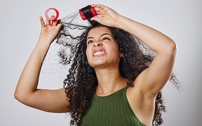 Buy stock photo Shot of a woman frowning while pulling rollers out of her hair