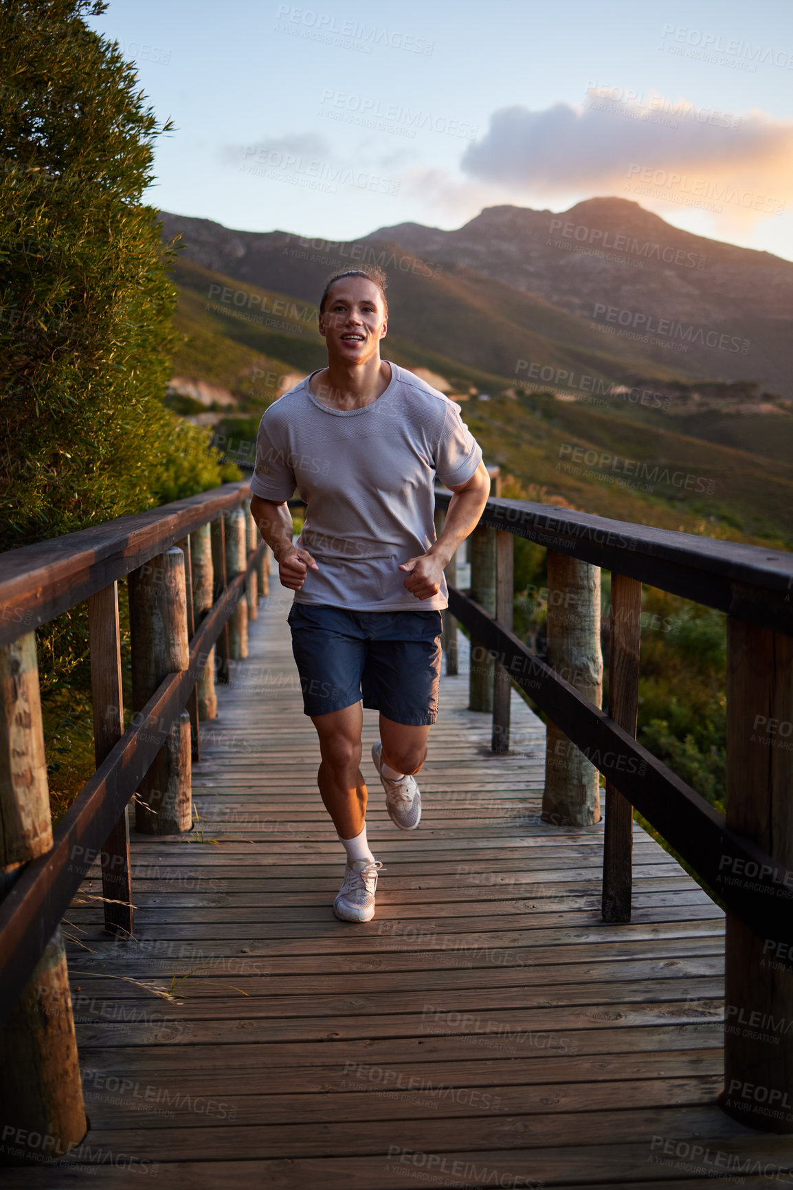 Buy stock photo Running, exercise and man in nature in morning for fitness, marathon training and workout. Sports, sunrise and male runner on footbridge, cardio and outdoors for performance, wellness and health