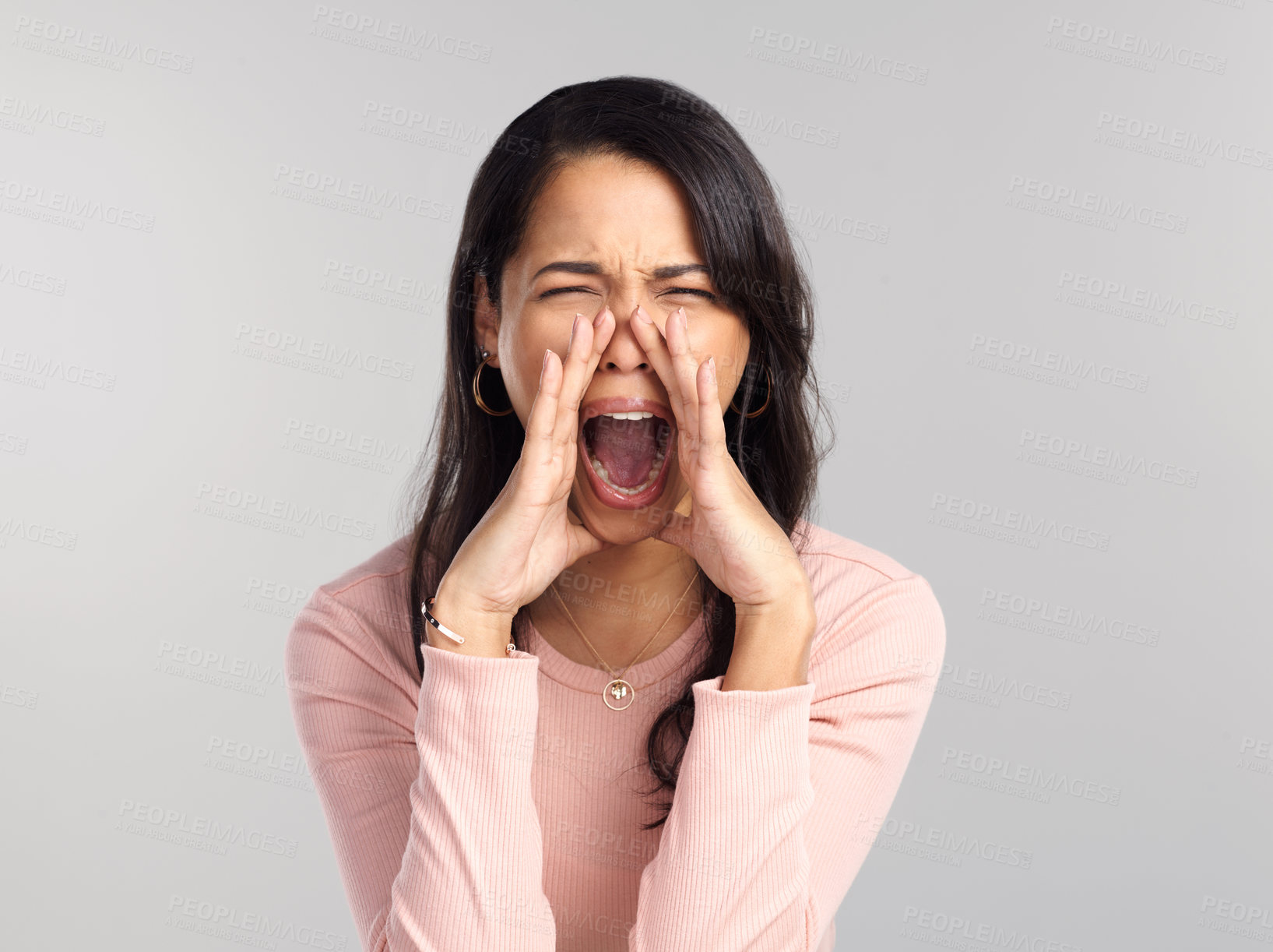 Buy stock photo Shot of a beautiful young woman shouting while standing against a grey background