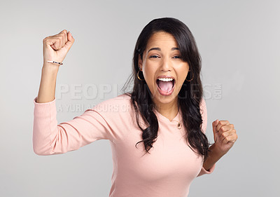 Buy stock photo Shot of a beautiful young woman looking cheerful while standing against a grey background