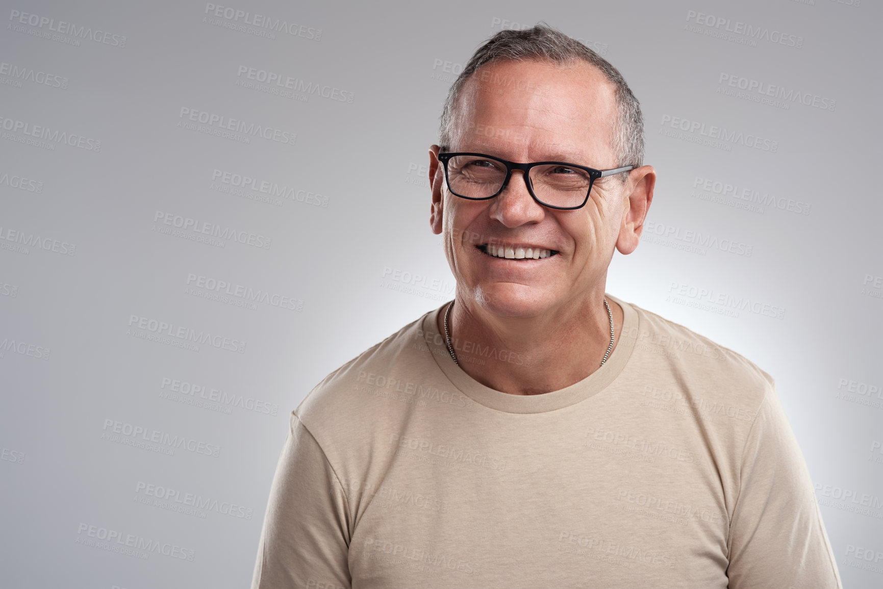 Buy stock photo Shot of a handsome mature man standing alone against a grey background in the studio during the day