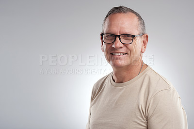 Buy stock photo Shot of a handsome mature man standing alone against a grey background in the studio during the day