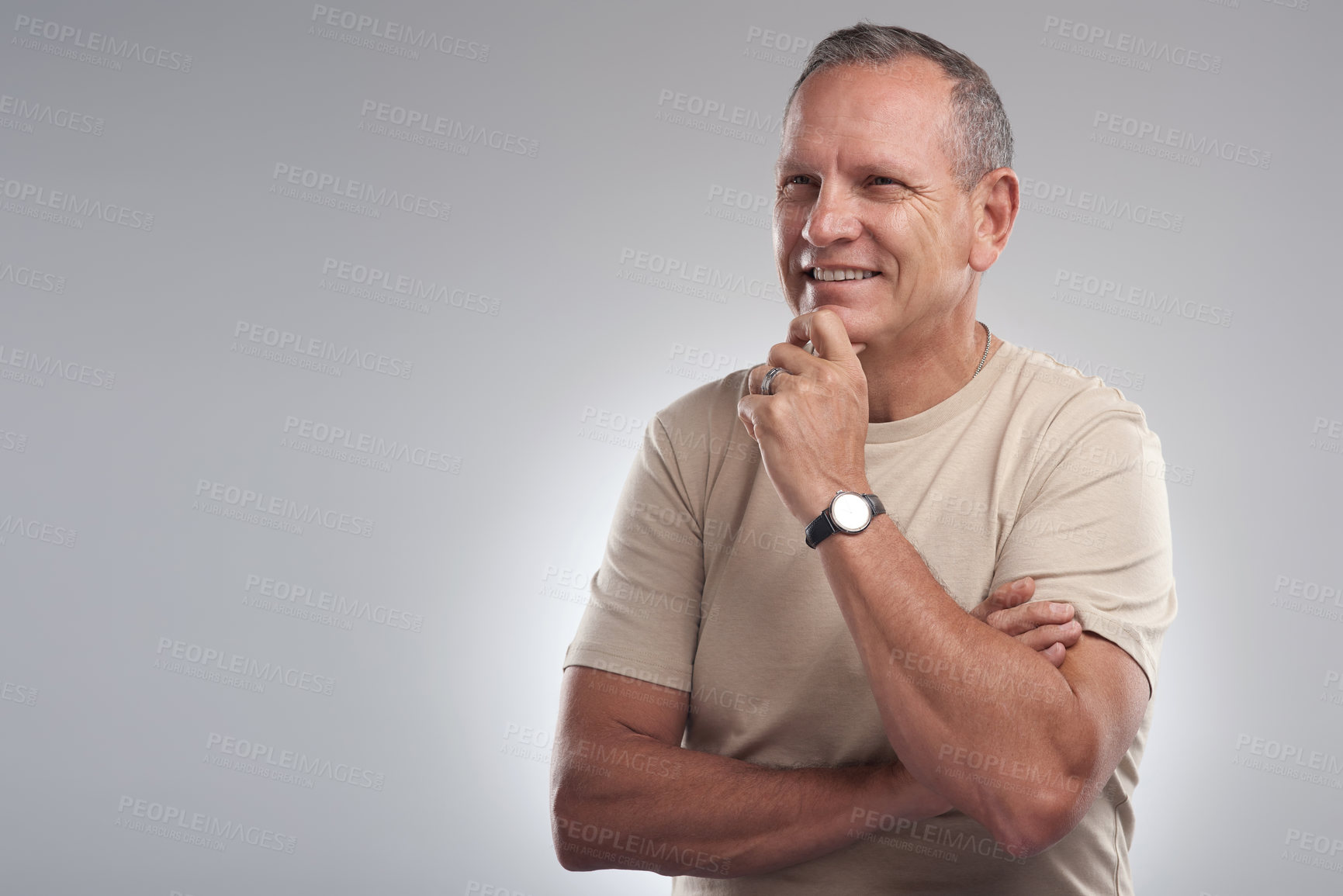 Buy stock photo Shot of a handsome mature man standing alone against a grey background in the studio and looking contemplative