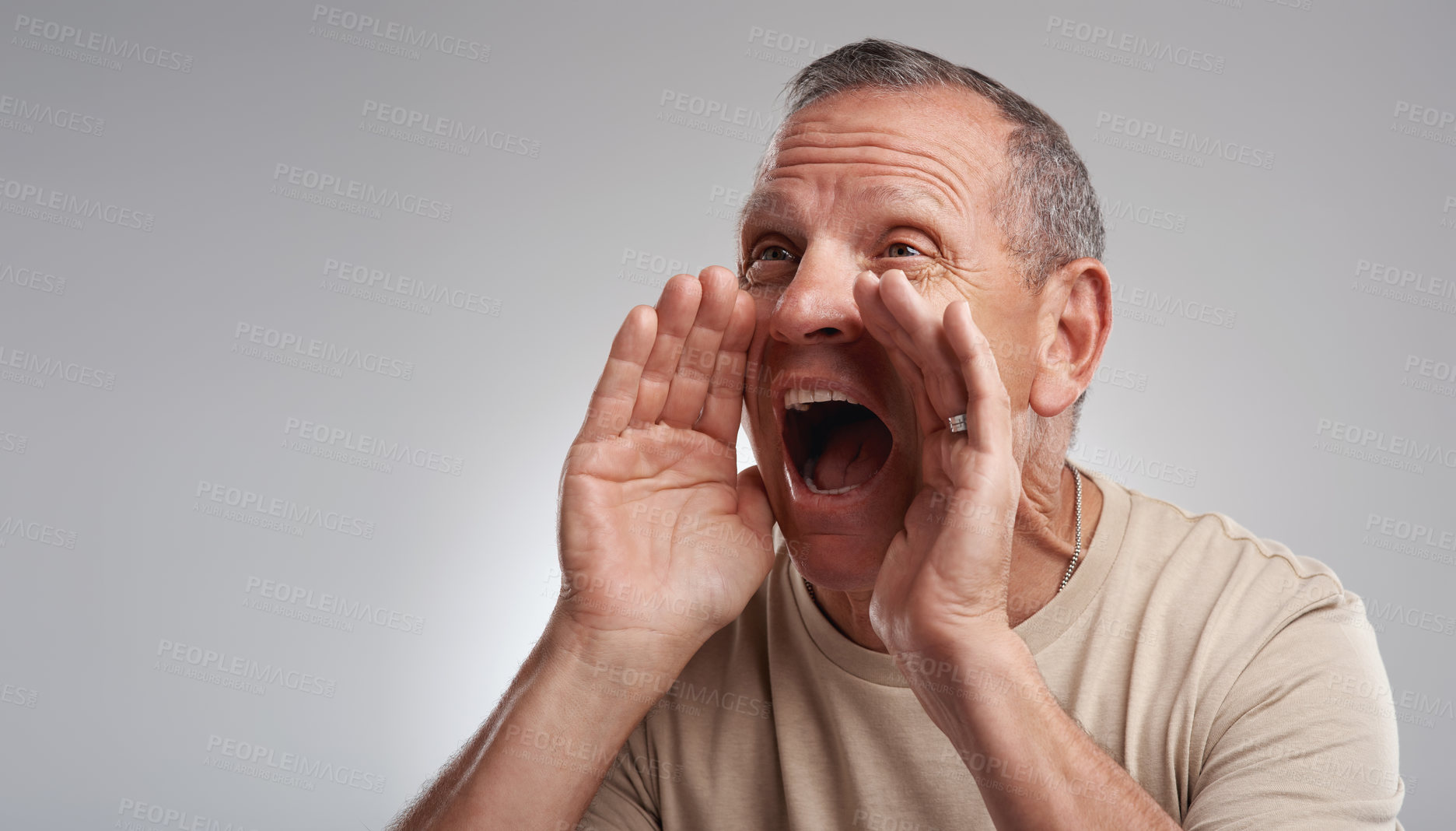 Buy stock photo Shot of a handsome mature man standing alone against a grey background in the studio and shouting