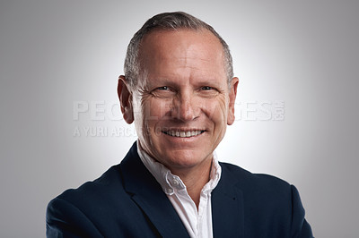 Buy stock photo Shot of a handsome mature businessman standing alone against a grey background in the studio