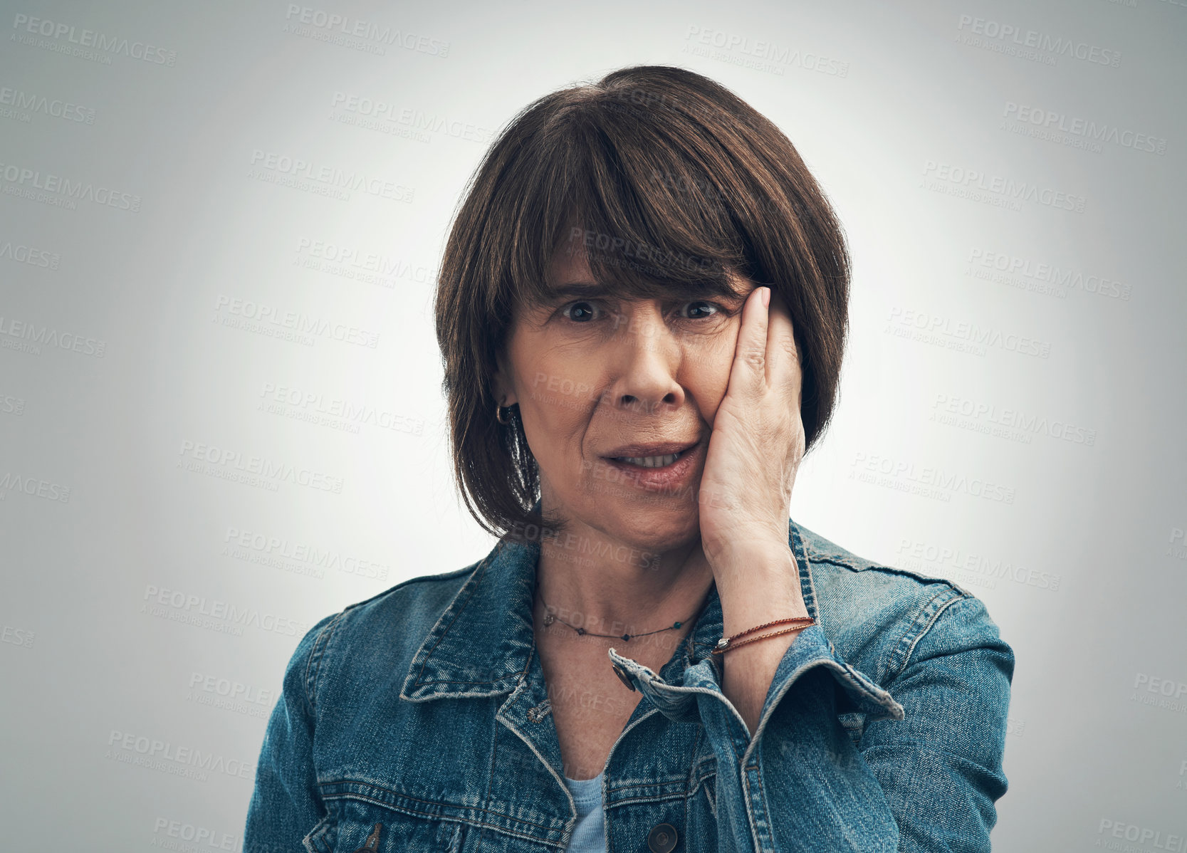 Buy stock photo Studio portrait of a senior woman looking shocked against a grey background