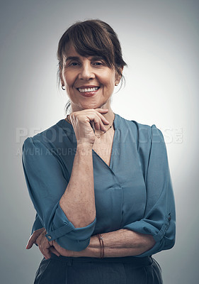 Buy stock photo Studio portrait of a senior woman posing with her hand on her chin against a grey background