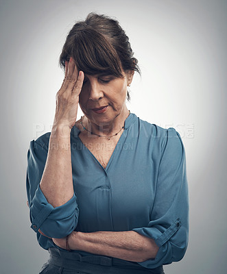 Buy stock photo Studio shot of a senior woman looking stressed out against a grey background
