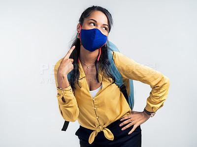 Buy stock photo Studio shot of a woman pointing at her mask while standing against a white background