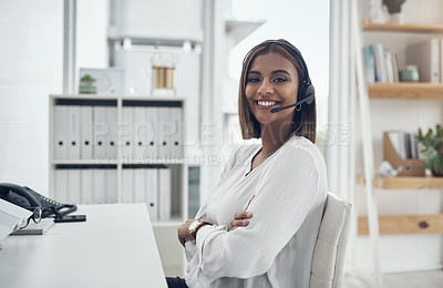 Buy stock photo Shot of an attractive young businesswoman sitting alone in her office with her arms folded and wearing a headset