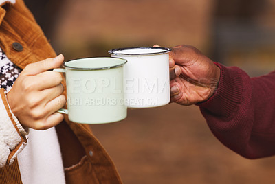 Buy stock photo Cropped shot of a couple sharing a toast with their coffee mugs while out in the wilderness