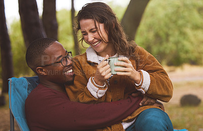 Buy stock photo Shot of a woman sitting on her boyfriend's lap while out camping in the wilderness
