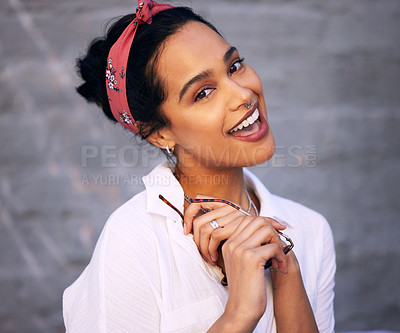 Buy stock photo Shot of an attractive young woman standing alone against a grey wall outside and posing during the day