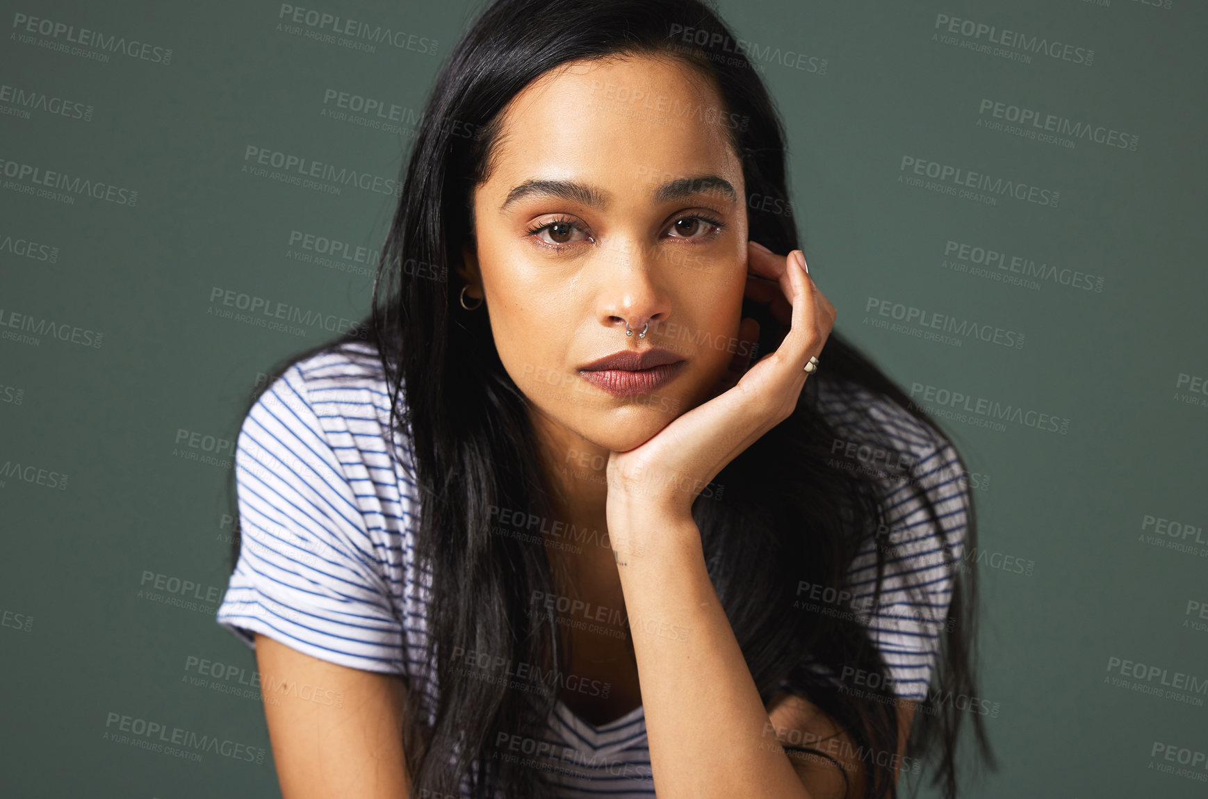 Buy stock photo Cropped portrait of an attractive young woman looking depressed against a green background in studio