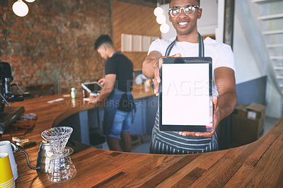 Buy stock photo Shot of a young man showing a digital tablet with a blank screen while working in a cafe