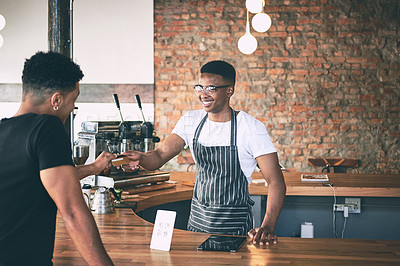 Buy stock photo Shot of a man using a credit card to make a payment in a cafe