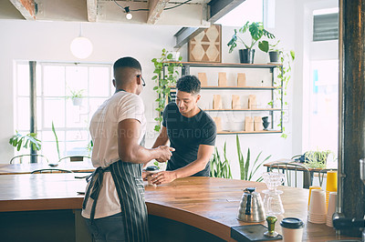 Buy stock photo Shot of a young man being served coffee in a cafe