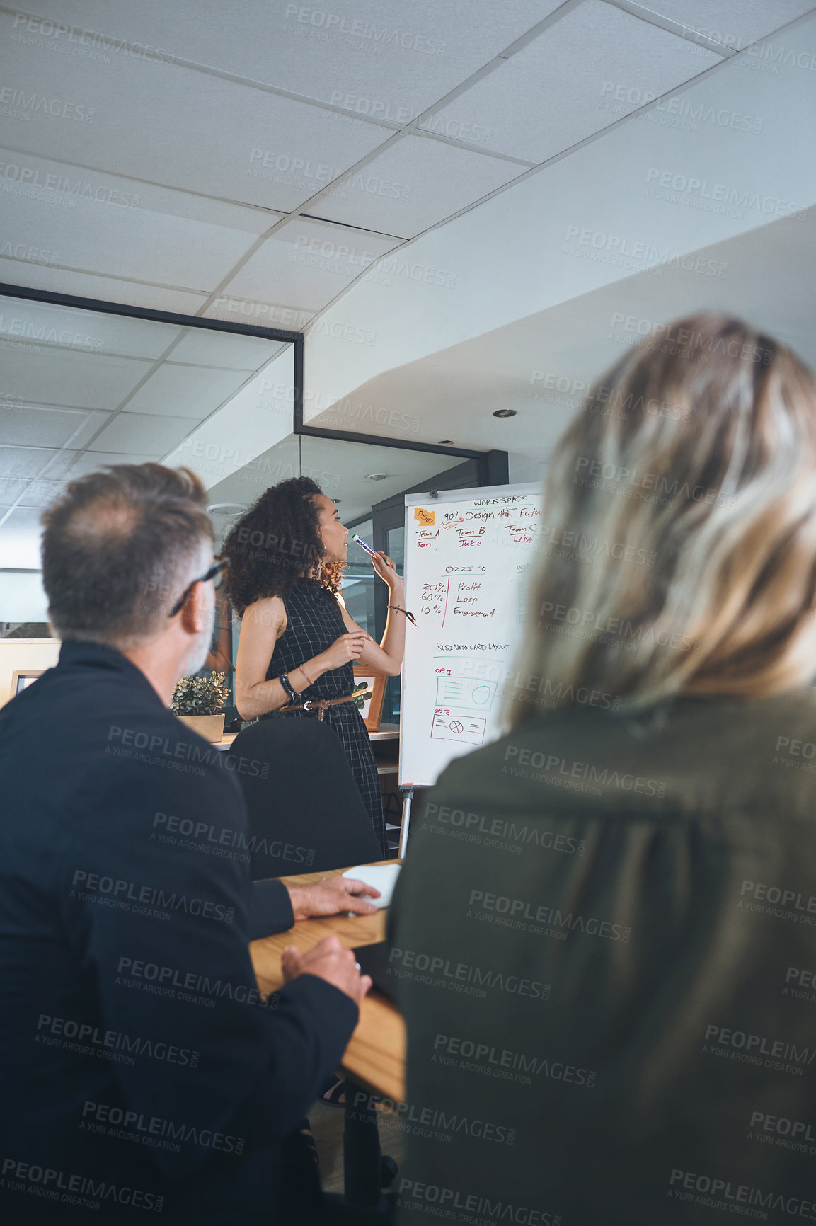 Buy stock photo Shot of a young businesswoman delivering a presentation to her coworkers in the boardroom of a modern office