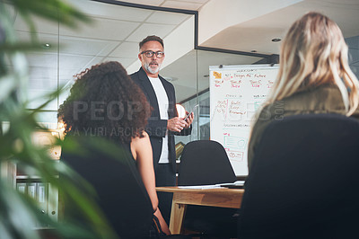 Buy stock photo Shot of a mature businessman delivering a presentation in the boardroom of a modern office