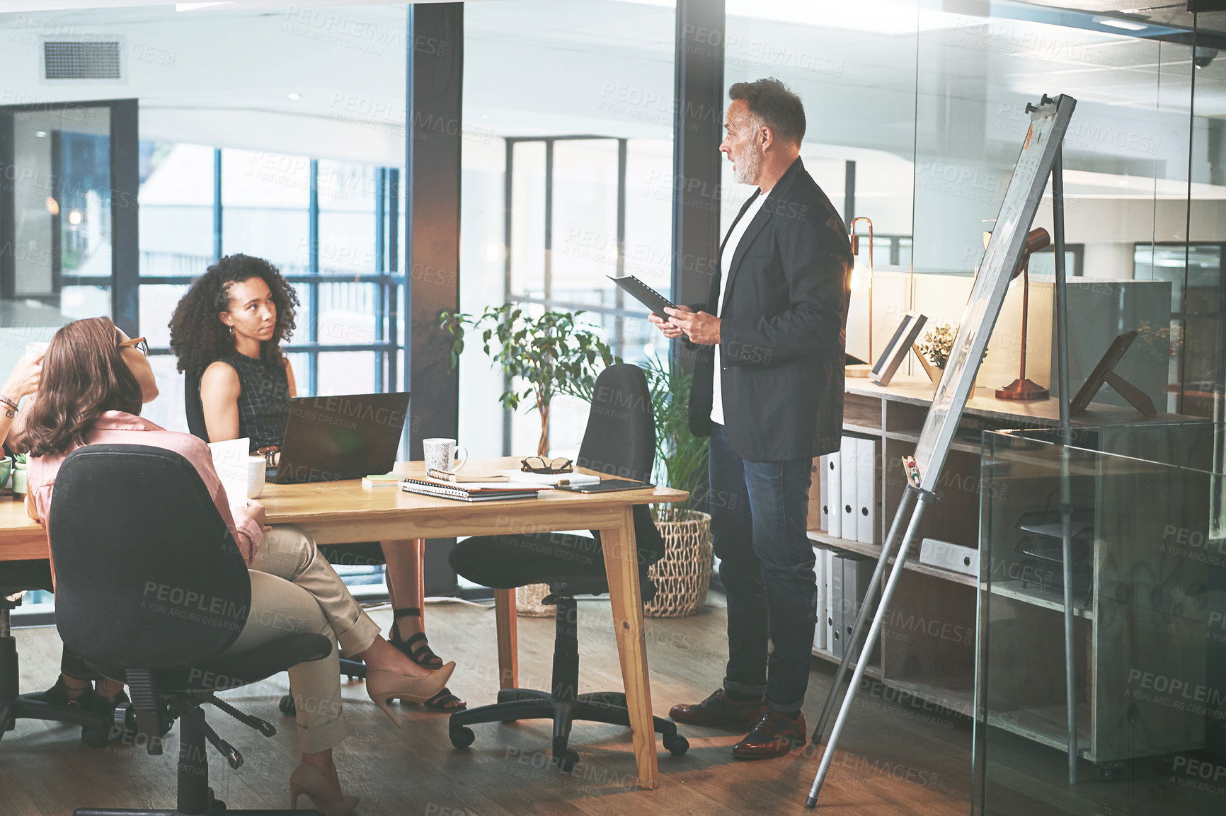 Buy stock photo Shot of a mature businessman delivering a presentation in the boardroom of a modern office