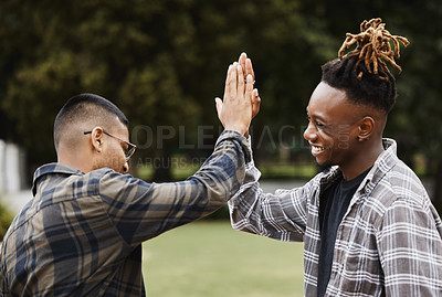 Buy stock photo Shot of two young men giving each other a high five on campus