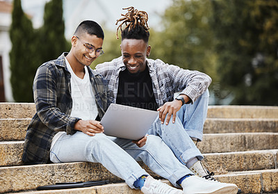Buy stock photo Shot of two young men using a laptop on campus