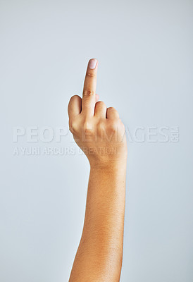 Buy stock photo Studio shot of an unrecognizable woman showing her middle finger against a grey background