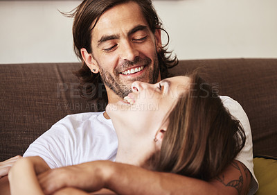 Buy stock photo Shot of a young couple relaxing on the couch at home