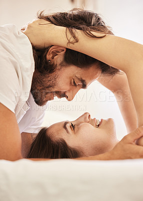Buy stock photo Shot of a young couple having an intimate moment on the bed at home