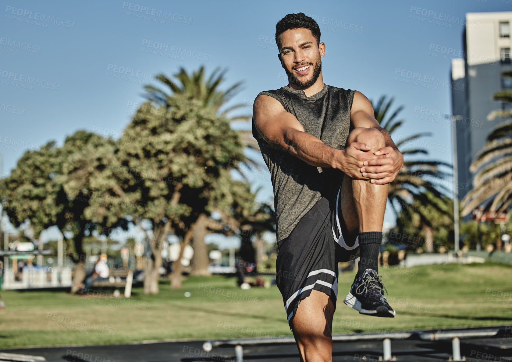 Buy stock photo Exercise, leg and stretching for male athlete, hip and mobility for warm up and outdoor run training. Portrait, smile and muscle for sports in field park, nature and man person for healthy workout