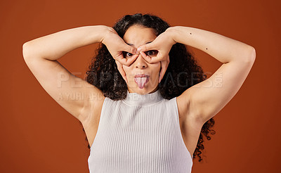 Buy stock photo Cropped portrait of an attractive young woman making a face in studio against a red background