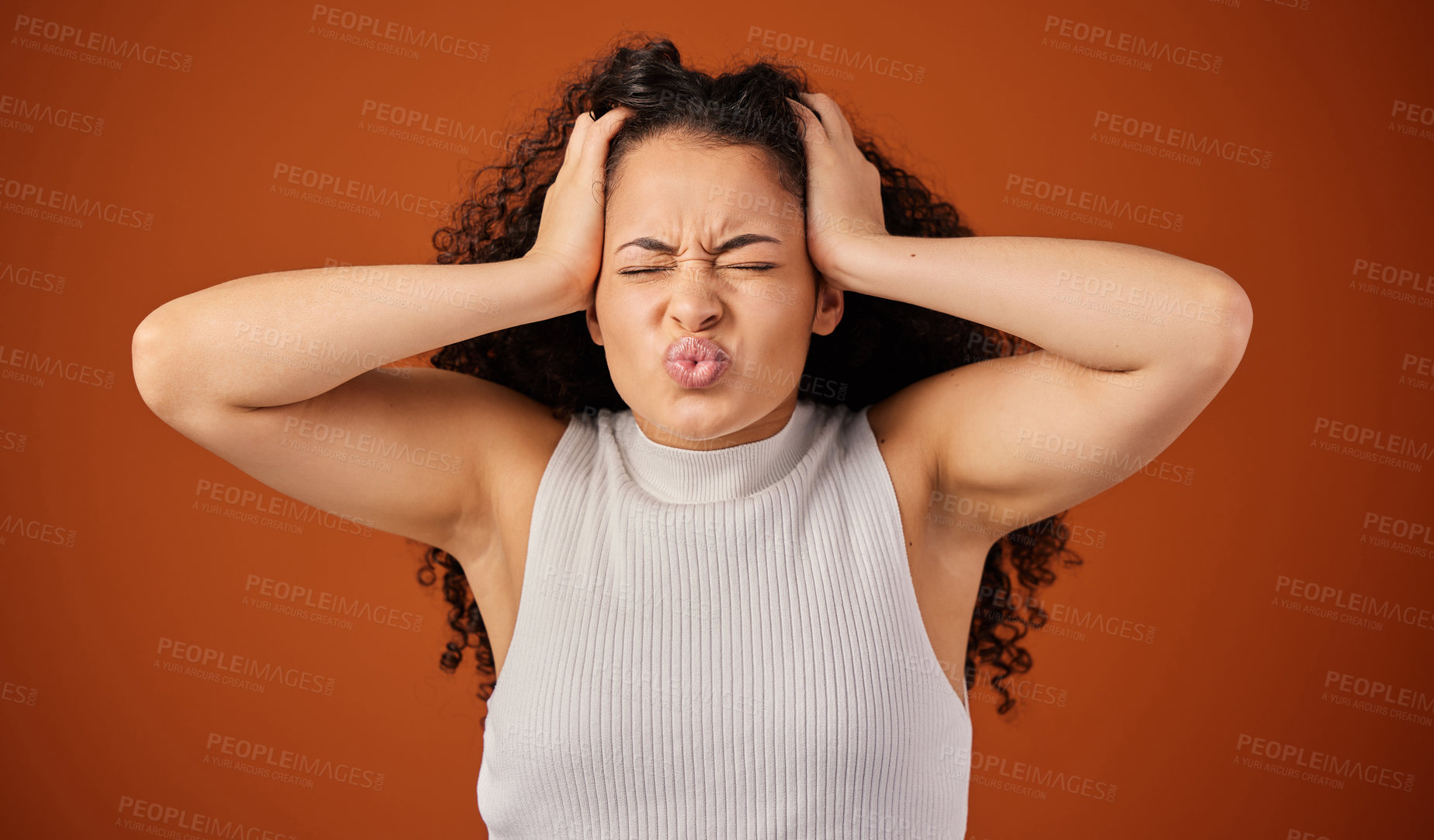 Buy stock photo Cropped shot of an attractive young woman looking frustrated in studio against a red background