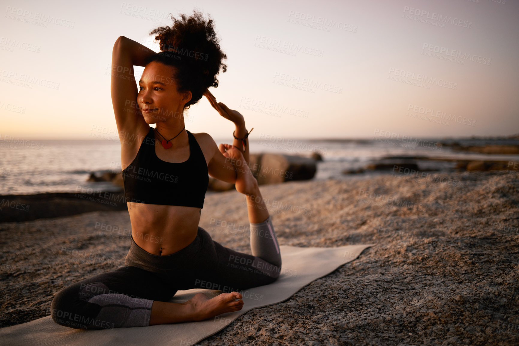 Buy stock photo Full length shot of an attractive young woman practicing yoga on the beach at sunset