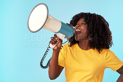 Buy stock photo Studio shot of an attractive young woman using a megaphone against a blue background