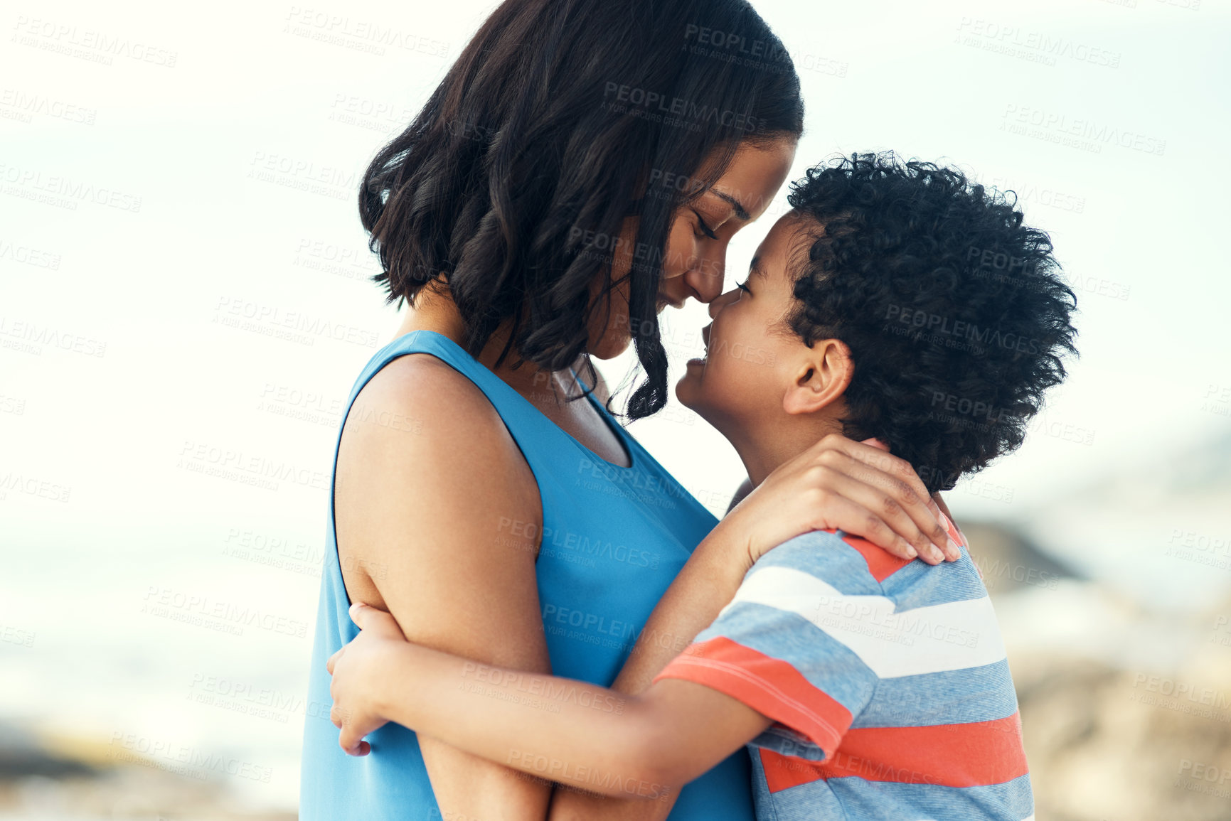 Buy stock photo Shot of a mother and her son embracing at the beach