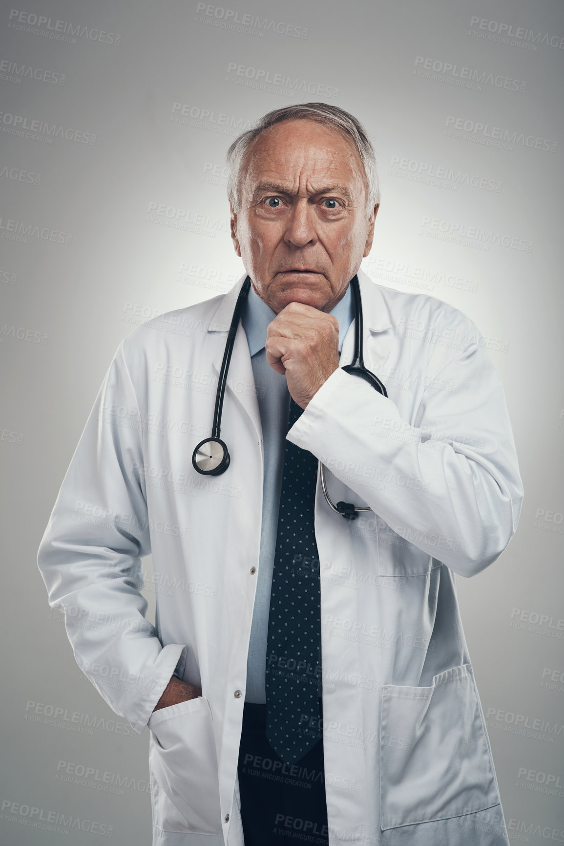 Buy stock photo Shot of an elderly male doctor in a studio against a grey background