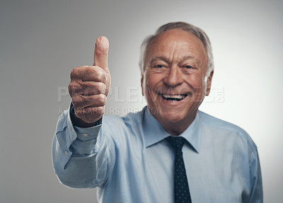 Buy stock photo Shot of a senior businessman standing alone against a grey background in the studio with his thumb up