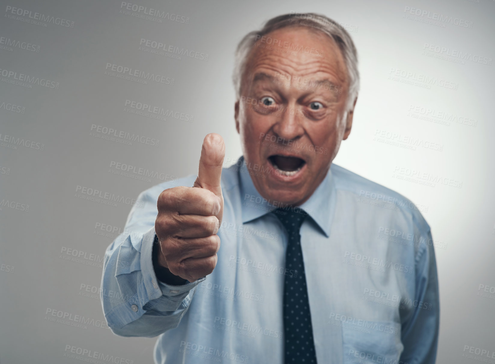 Buy stock photo Shot of a senior businessman standing alone against a grey background in the studio with his thumb up