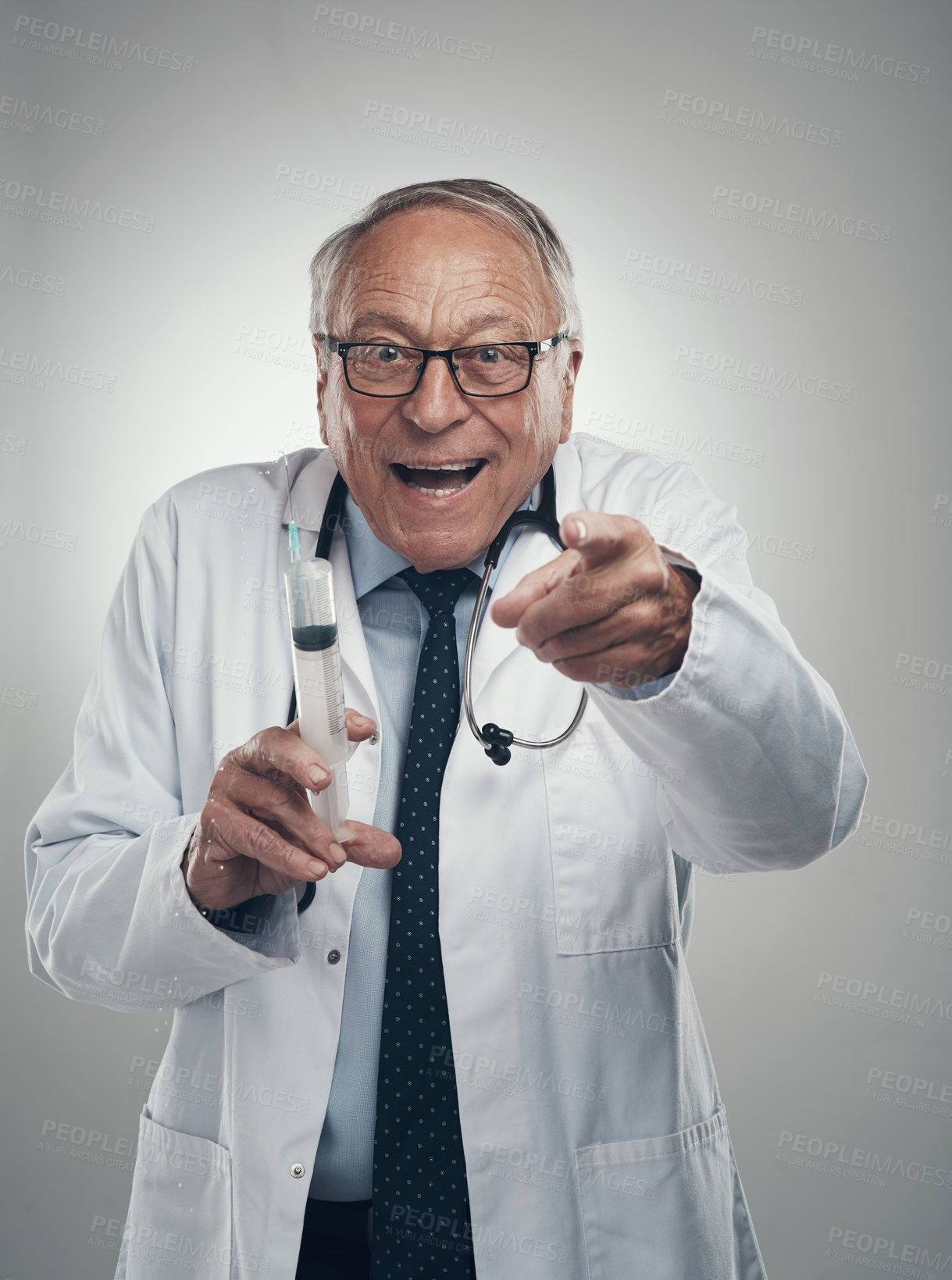 Buy stock photo Shot of an elderly male doctor holding a syringe for injection in a studio against a grey background