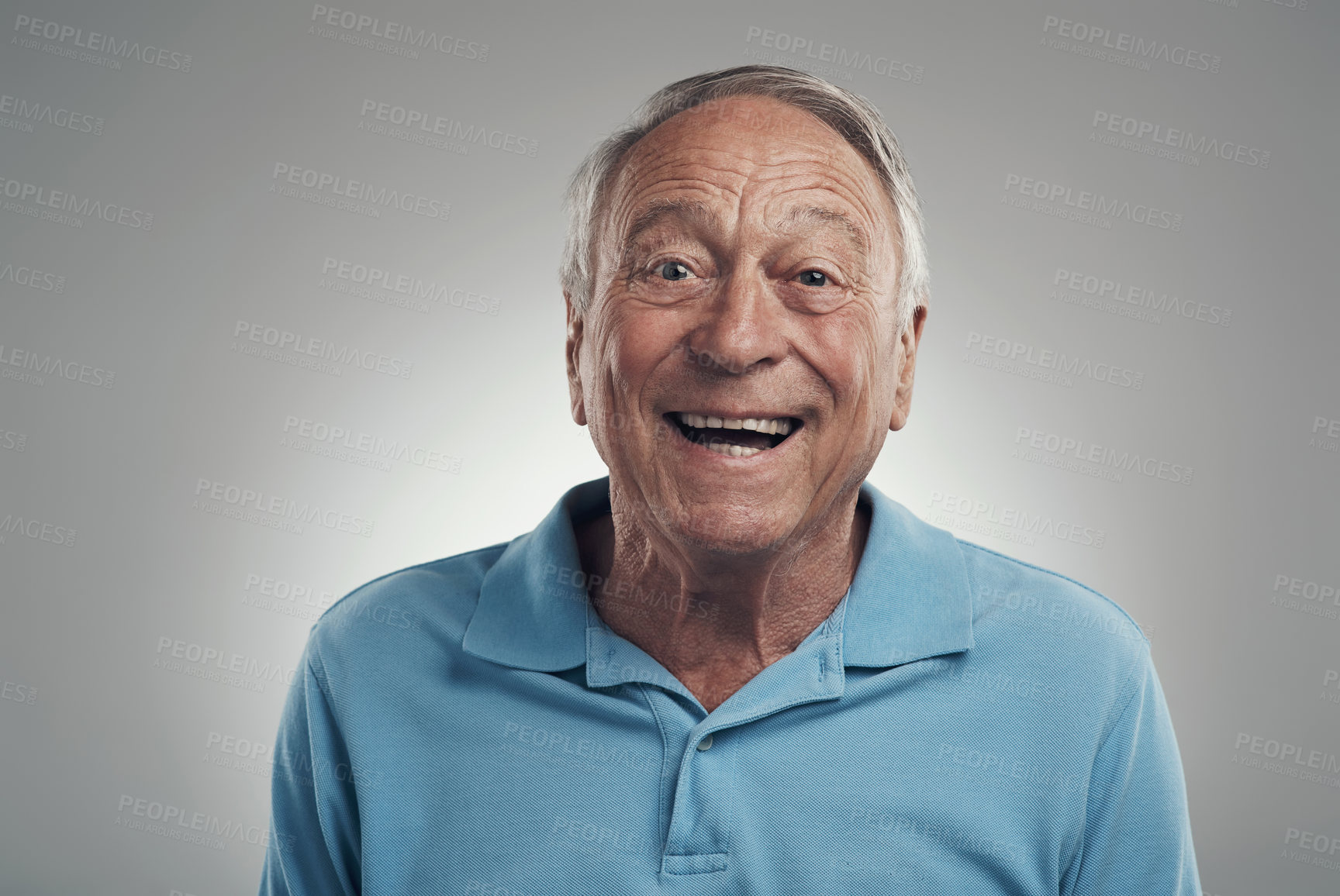 Buy stock photo Shot of a man happily smiling at the camera in a studio against a grey background