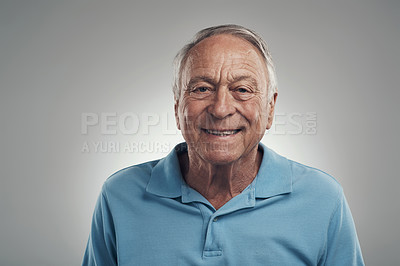 Buy stock photo Shot of a man happily smiling at the camera in a studio against a grey background