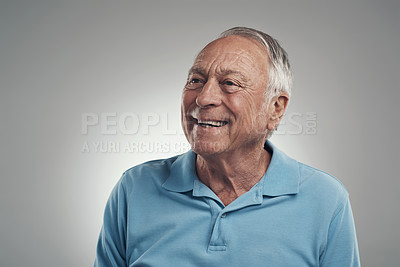 Buy stock photo Shot of an older man looking off into the distance in a studio against a grey background