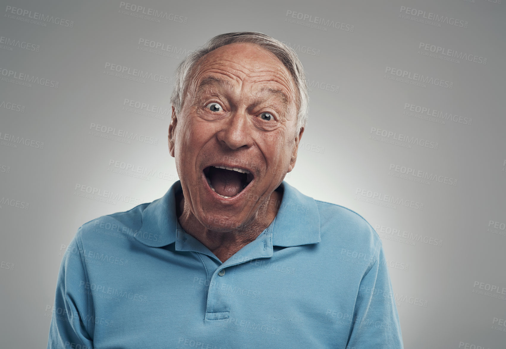 Buy stock photo Shot of an older man making an excited expression at the camera in a studio against a grey background