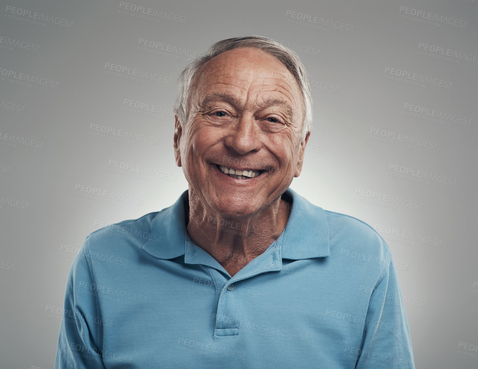 Buy stock photo Shot of a man happily smiling at the camera in a studio against a grey background