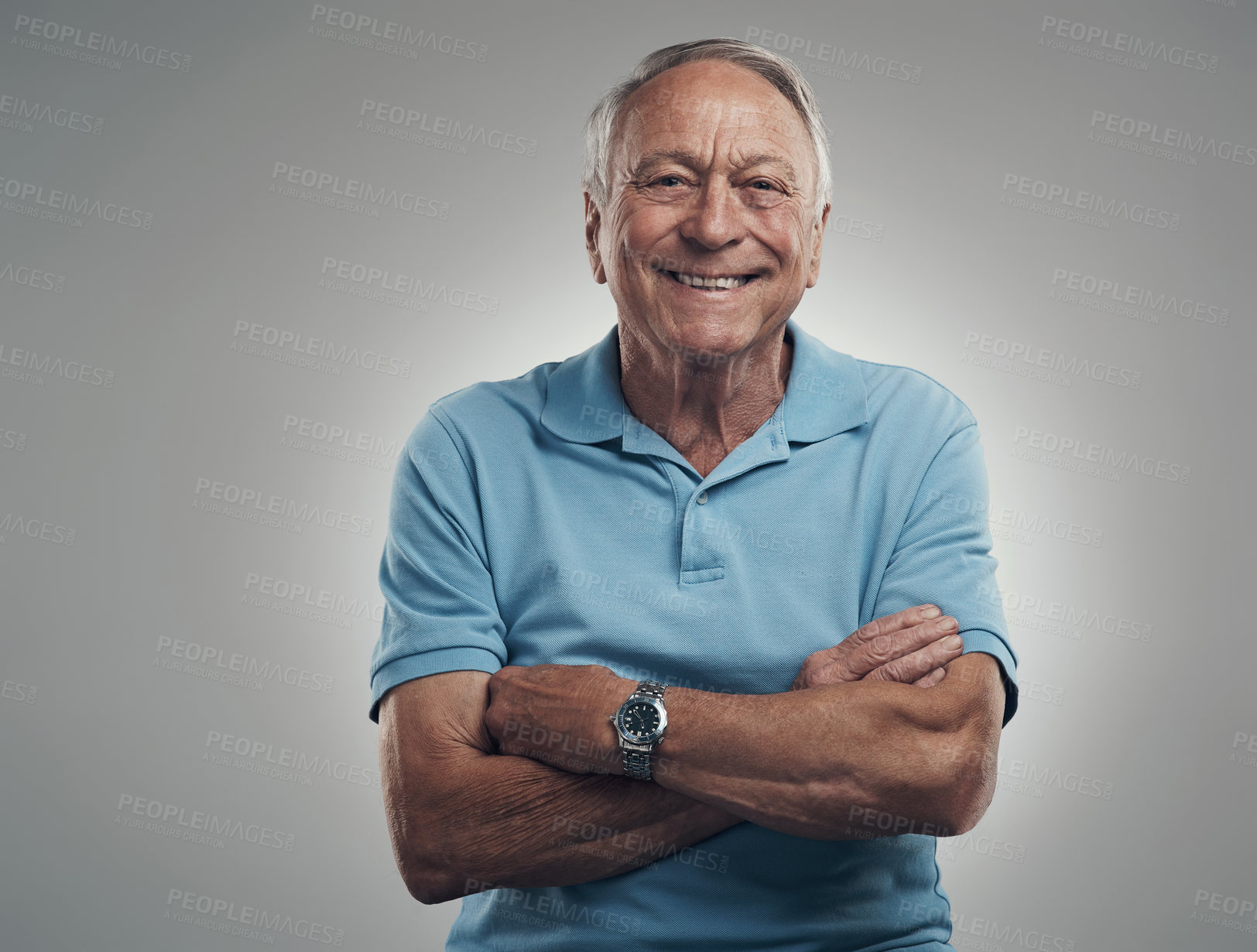 Buy stock photo Shot of an older man smiling at the camera with his arms crossed in a studio against a grey background