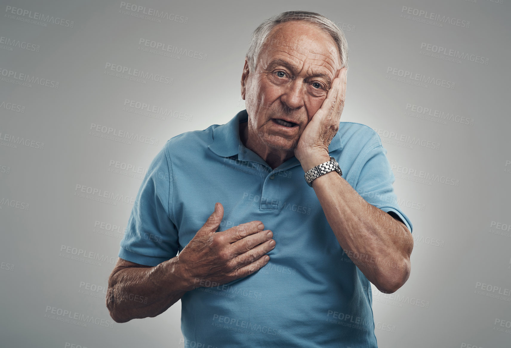 Buy stock photo Shot of an old man touching his hand to his face in a studio against a grey background