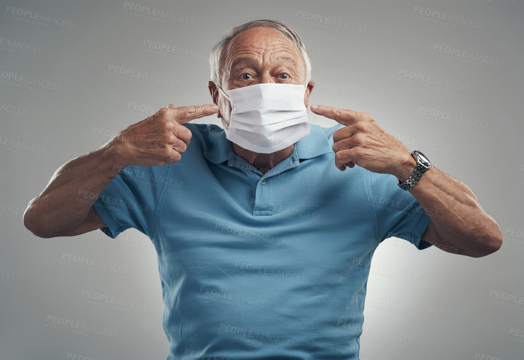 Buy stock photo Shot of an older man wearing a protective face mask in a studio against a grey background