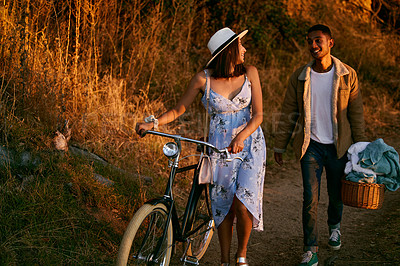 Buy stock photo Romantic, happy and couple on a picnic in a park for a date, holiday and love in Indonesia. Travel, smile and man and woman walking in nature for romance, peace and relax with food during sunset