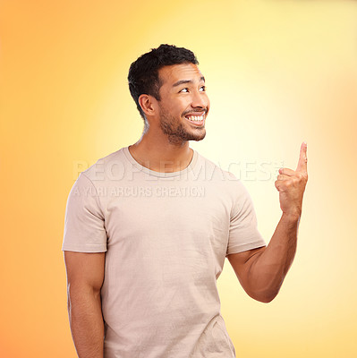 Buy stock photo Mockup, pointing up and man advertising in studio isolated on a yellow background. Thinking, branding and happy male model showing copy space for product placement, mock up or marketing promotion.